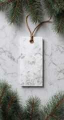 Blank marble gift tag, tied with brown twine, surrounded by pine boughs on a marble surface