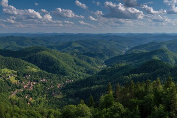 Fototapeta premium Lush green mountains stretch into the distance under a partly cloudy sky, with a small village nestled in the valley