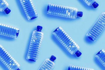 Clear single-use plastic water bottles on light blue background close-up pattern, minimal style...