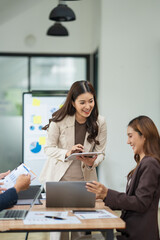 Group of business people are standing in a meeting presenting their work at the office.