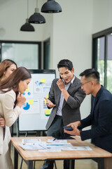 Group of business people are standing in a meeting presenting their work at the office.