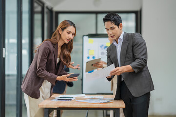 Group of business people are standing in a meeting presenting their work at the office.