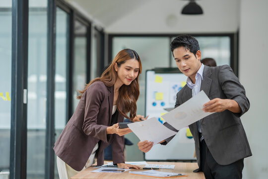Group of business people are standing in a meeting presenting their work at the office.