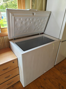 White chest freezer with open lid in a cozy kitchen setting showcasing storage space
