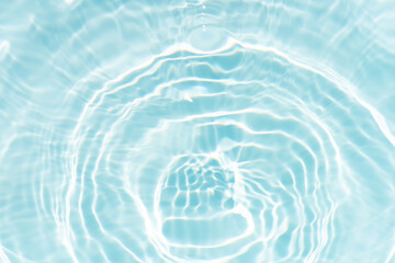 Blue water with ripples on the surface. Defocus blurred transparent blue colored clear calm water surface texture with splashes and bubbles. Water waves with shining pattern texture background.