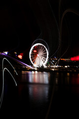 Ferris wheel at night with motion blur, abstract light trails
