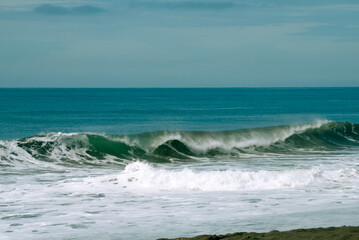 Powerful ocean wave breaking on volcanic beach