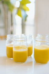 Four jars of butternut squash soup resting on kitchen counter