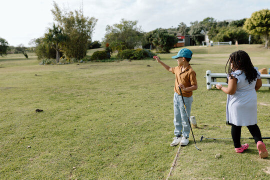 Young boy playing golf with cap
