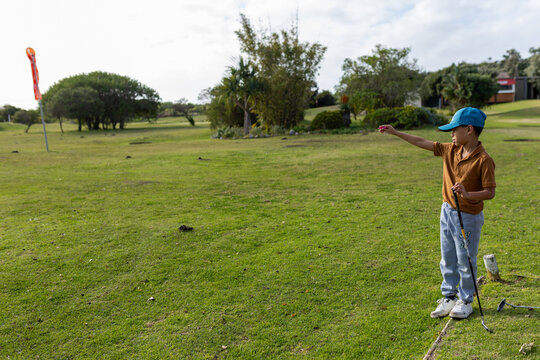 Young mixed race boy playing golf