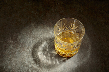 Crystal glass of whiskey on a old stone table.