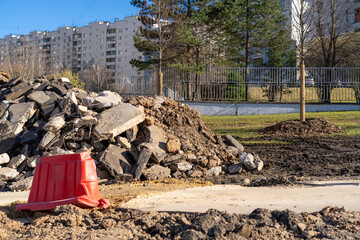 Urban street reconstruction with a large pile of demolished pavement and concrete in a residential...