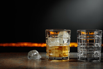 Whiskey with ice on a dark background.