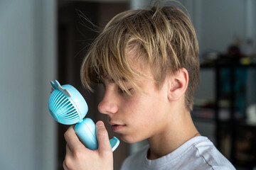 Concept of personal comfort and cooling on a warm day, a young individual seeking refreshment with...