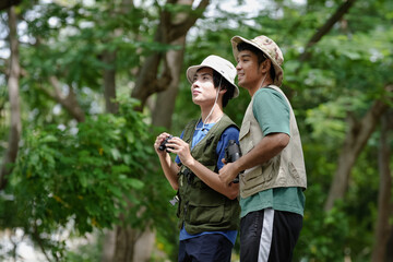 Bird watching is recreational pursuit. Young man and friend have fun with outdoors leisure activity...