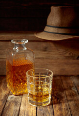 Elegant whiskey glass and decanter on a old wooden table.