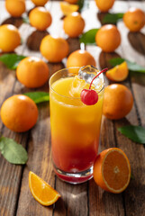 Classic tequila sunrise cocktail on an old wooden table.