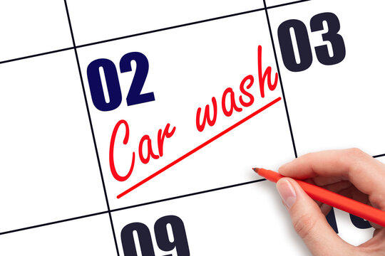 2nd day of the month.  Hand writing Car wash reminder and drawing a line on calendar with red pen on white background. Vehicle maintenance reminder. Planning and scheduling