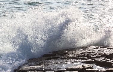 The ocean is rough and the waves are crashing against the rocks