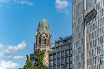 Kaiser Wilhelm Church and Kurfurstendamm. The old tower of Kaiser Wilhelm Church rises behind trees...