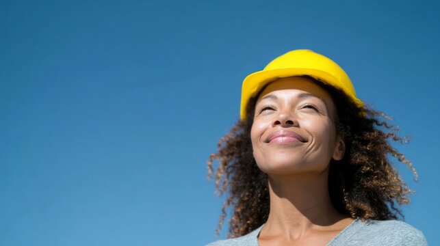 African American woman in hard hat, basking under the cerulean sky, embodies Labor Day optimism and steely resilience