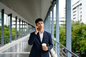 Asian businessman having a phone conversation during a morning commute