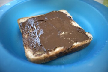 A slice of peanut butter bread on a blue plate close up