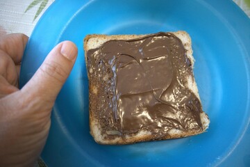 A slice of peanut butter bread on a blue plate close up