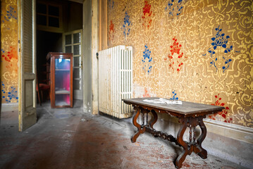 Abandoned Vintage Dining Room with Red Chairs and Peeling Wallpaper	