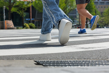 Low-angle of two people crossing intersection showcases motion. Captured mid-stride, highlights...