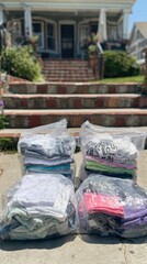 Neatly packed clothes in transparent vacuum bags placed on outdoor steps ready for storage donation or moving perfect for household organization visuals and minimal packing ads