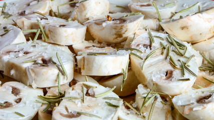 Primer plano de champiñones laminados con sal gruesa y romero. 