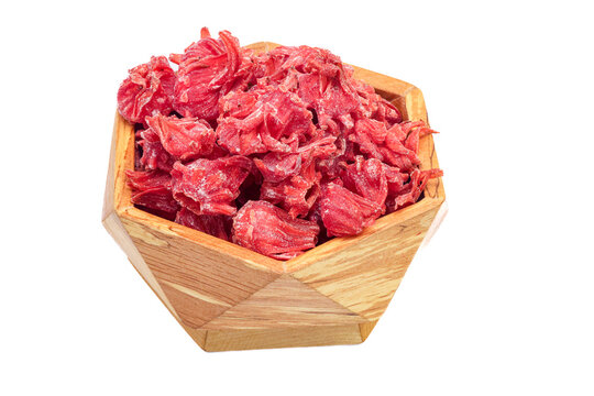 A wooden hexagonal bowl filled with bright red, shredded dried fruit leather strips. The deep crimson color and fibrous texture suggest a tart flavor, possibly pomegranate or berry-based.