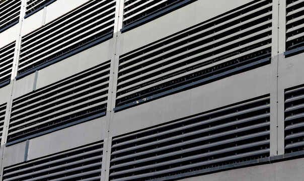 Ventilation facade closeup. Modern building exterior with metal louver system, grid pattern, airflow