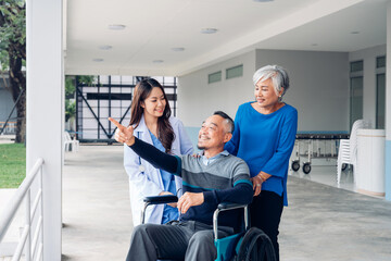 Obraz premium Doctor taking care and talking mature male patient sitting on wheelchair.