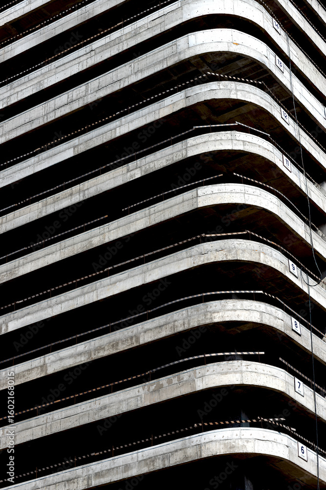 Poster building under construction. concrete structure with multiple floors, balconies, raw framework,