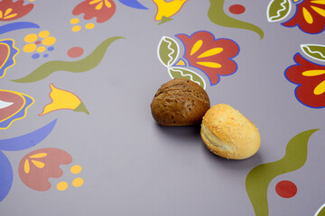 two buns, buckwheat and white, on a gray background