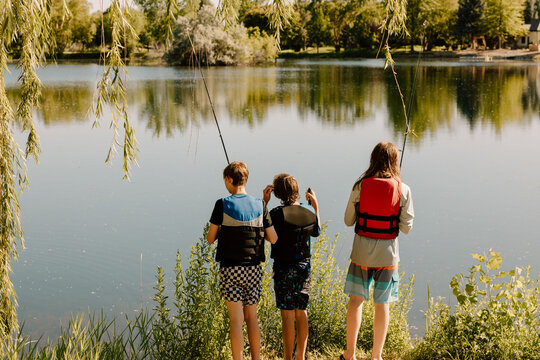 Three young fishermen patiently waiting for a bite on a sunny day
