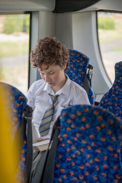 Teenage girl reading a book in the bus, Gen Z lifestyle