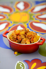 stewed potatoes in a red frying pan vertical photo