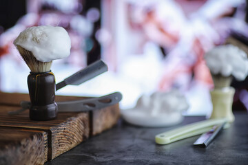 Shaving accessories on a wooden texture background. Tools. Disposable shaving machine, brush, foam...