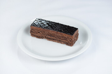 chocolate cake in chocolate glaze on a white plate