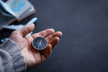 Travel concept. Magnetic compass in the hand. Retro navigator in hand a map and airplane...
