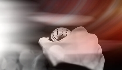 Abstract car background. The driver switches the speed in the car. Hand on gear lever.