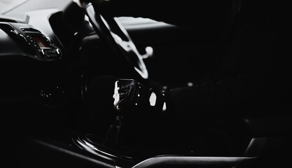 Hand on the car gear knob. The driver switches the speed in the car. Hand on gear lever.