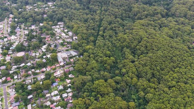 South Coast, NSW, Australia: Smooth Drone Flight from the Panorama House at Bulli Pass Lookout, over the Illawarra mountain range forest to the train line in Thirroul, a seaside resort town.