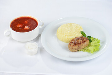 lunch borscht with cutlet and side dish on a white background
