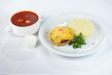 lunch borsch with chop and side dish on a white plate