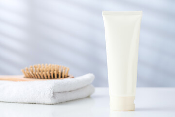 White Skincare Cream Tube with Towel and Hairbrush Hair and Skin Care concept