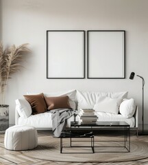 Minimalist living room with white sofa. two black framed pictures. a glass coffee table. and a white ottoman